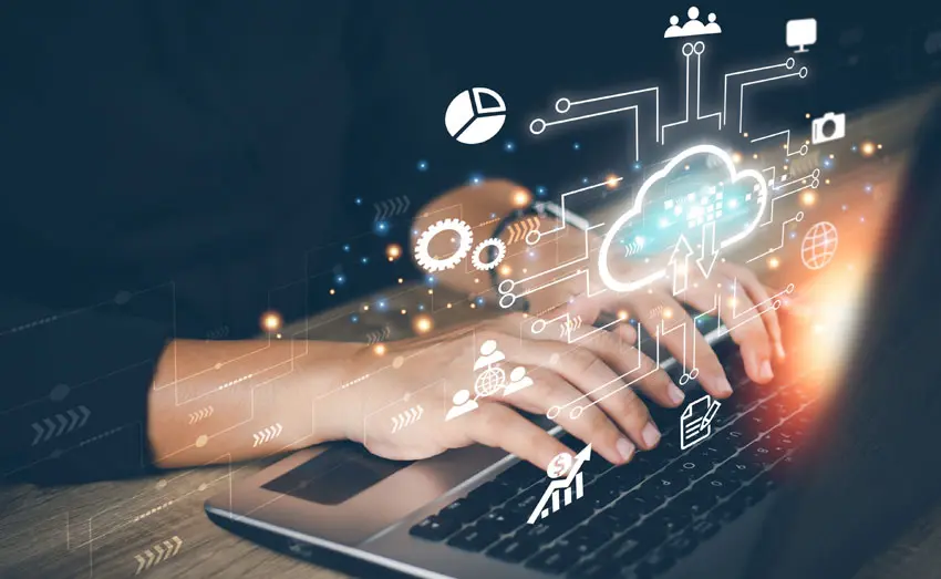 Close-up of hands typing on a laptop with graphical AI elements like cloud computing, data analytics